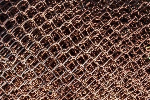Old metal grid covered with rust and blured brown background. Stock Photos