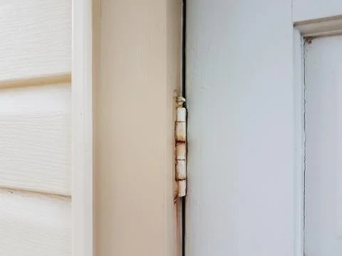 Old metal hinge with rust on white door Stock Photos