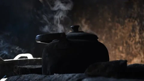Old metal kettle with boiling water on a traditional stove Stock Footage 142306310