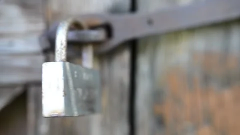 Old metal lock swinging on a rusty hinge on a dilapidated wooden shed. Stock Footage 142087675