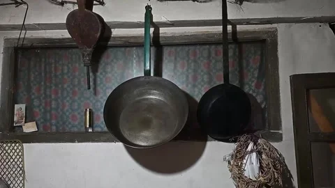 Old metal pans hanging in a rustic home kitchen interior Stock-Footage 320407456