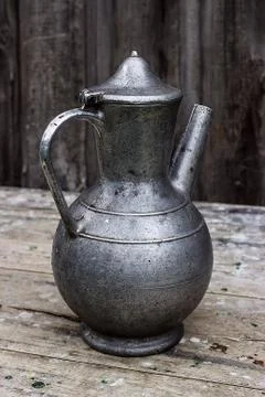 Old metal pitcher on a table Stock Photos