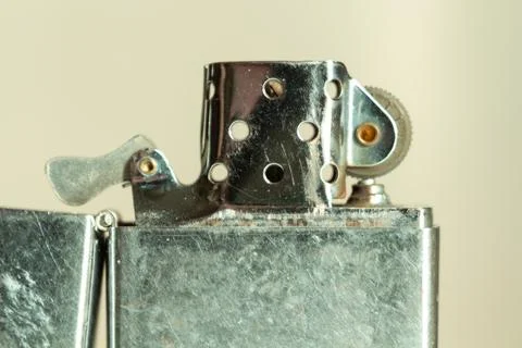 Old metallic accessory for lighting fire shows signs of age and heavy usage 库存照片