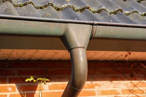Old metallic gutter downspout system on brick wall Stock Photos