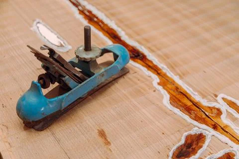 Old metallic jointer plane laying on wood table Stock Photos