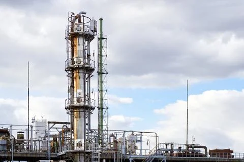 Old methanol distillation rectification refinery column towers under cloudy sky Stock Photos