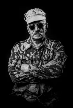 Old military man in glasses isolated on a black background Stock Photos