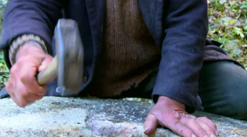 Old miller sharpening a grain stone mill wheel with a hammer Stock Footage 51572275