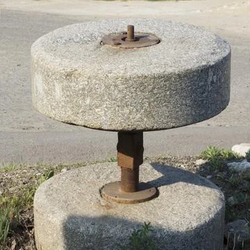 Old millstone for the mill. Stock Photos