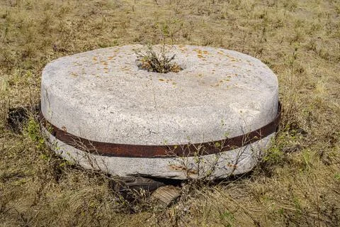 An old millstone from a windmill lying on the grass Stock Photos