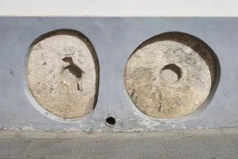 Old millstones embedded to prevent carriages from breaking the walls in The.. Stock Photos