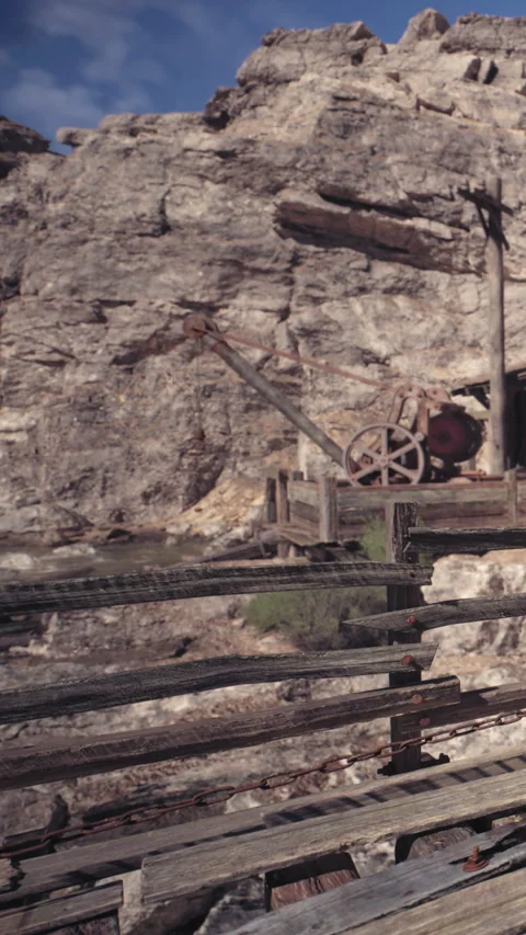 Old mining equipment sits near a rocky hill in an abandoned area Stock Footage 339034346