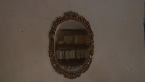 Old mirror with a bookcase in its reflection Stock Footage 87084327