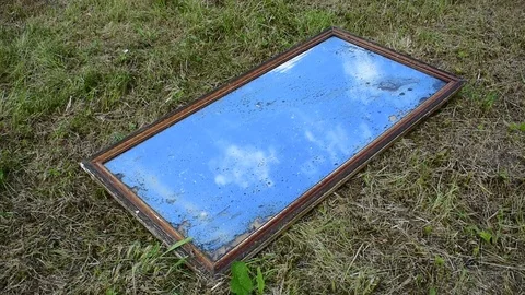 Old mirror in the frame lies on the grass Stock Footage 117111923