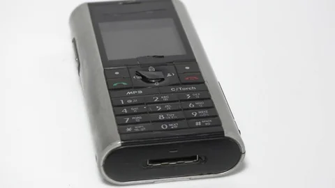 Old mobile phone on display and rotating on white Video stock 111887827