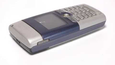 An old mobile phone with display screen and on white base moving Video stock 111887793