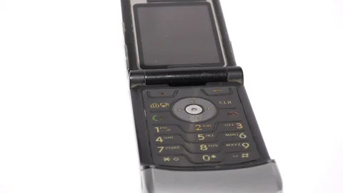 An old mobile phone with flip pad on white surface Video stock 111887756