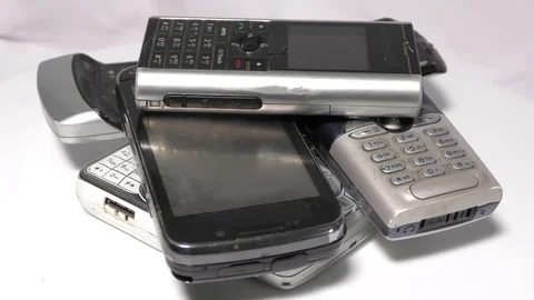 Old mobile phones on top of each other moving on white Video stock 111887862