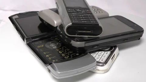 Old mobiles in stack and pile moving in circular motion on white Stock Footage 111887870