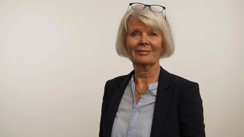 Old model talking on phone and removing glasses Stock Footage 107749522