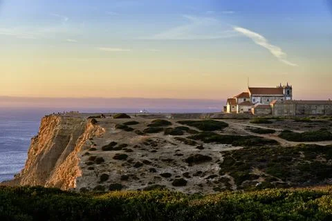 Old monastery on high cliff over seascape at sunset, Portugal Stock Photos