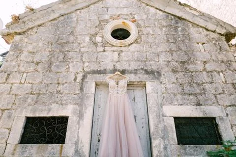 Old monastery with windows with bars and wedding dresses at the entrance on a 스톡 사진