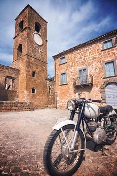 Old motorcycle parked in the square of the ghost town of Celleno (Italy) Stock-Fotos
