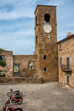 Old motorcycle parked in the square of the ghost town of Celleno (Italy) Stock Photos