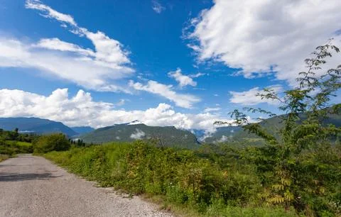 Old mountain road against the backdrop of mountains Stock Photos