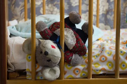 Old mouse toy in an empty crib Stock Photos