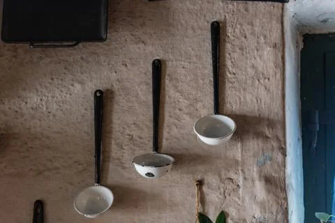 Old mud wall with antique cooking spoons hanging on it Stock Photos