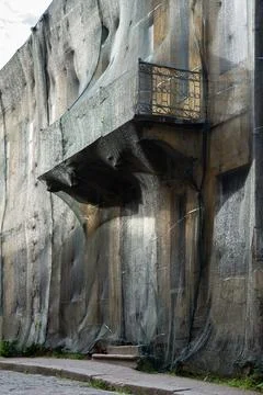 Old multi-storey building with balcony closed with construction grid for period Stock Photos