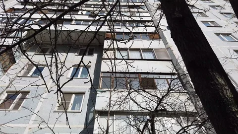 Old multi-storey building behind bare tree branches. Bottom view. Video stock 129004694