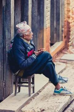 Old Nepalese man sitting in front of his home in Nepal Stock Photos