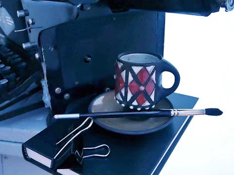 Old objects - a typewriter, a black cup on a book Stock Photos