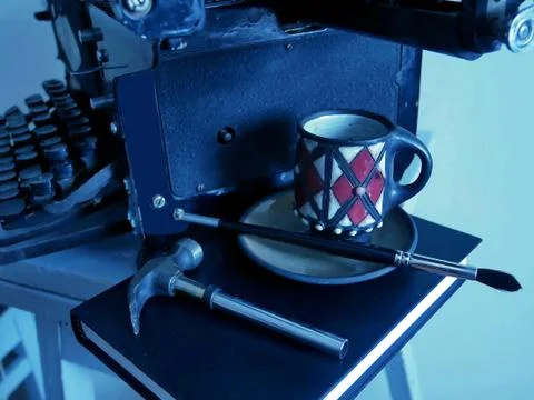 Old objects-a typewriter, a black cup on a book and a hammer Stock Photos