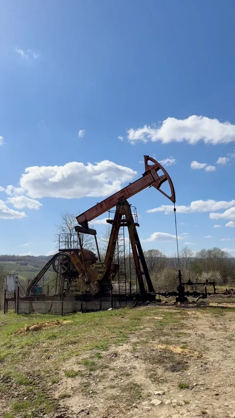 Old Oil Pump Jack (Nodding Donkey) Operating in Rural Field. Stock Footage 307137445