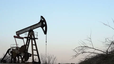 Old Oil Well Pump Jack Extracting Petroleum. Working Oil Pump Jack Against  Stock Footage 127797095