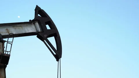 Old Oil Well Pump Jack Extracting Petroleum. Working Oil Pump Jack Against  Stock Footage 127797614