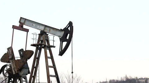Old Oil Well Pump Jack Extracting Petroleum. Working Oil Pump Jack Against  Stock Footage 127798767