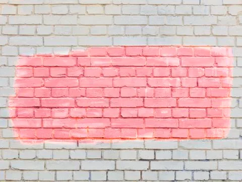 On the old old brick wall, the highlighted fragment is painted with coral pai Stock Photos