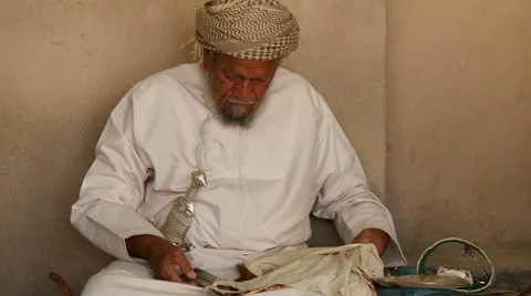 Old omani wraps traditional dagger (khanjar) in a lobe   closeup Stock Footage 50555595
