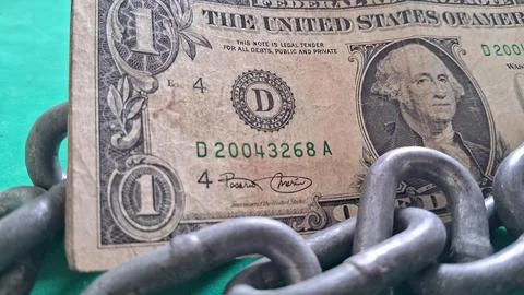 Old one dollar bill restrained by heavy weathered metal chains Stock Photos