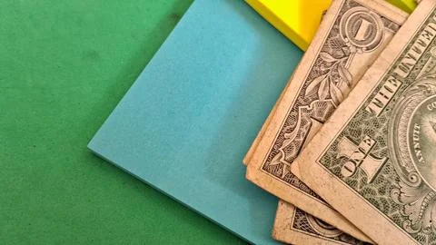 Old one dollar bills resting on bright colorful sticky notes Stock Photos