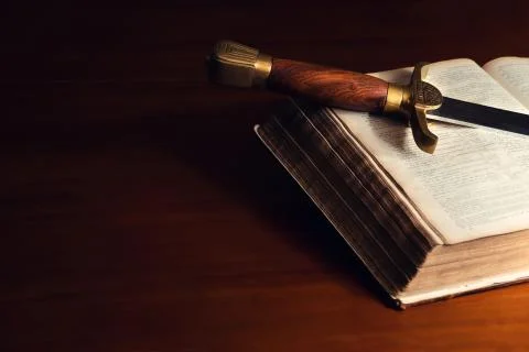 Old open bible with sword Stock Photos