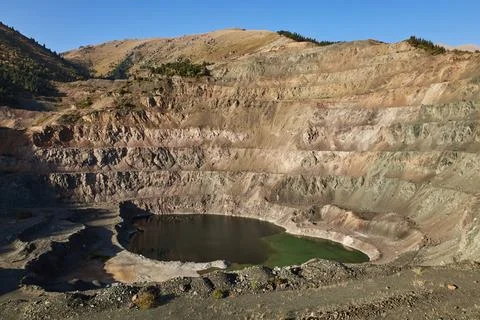 Old open mining pit with pond in mountain Stock Photos