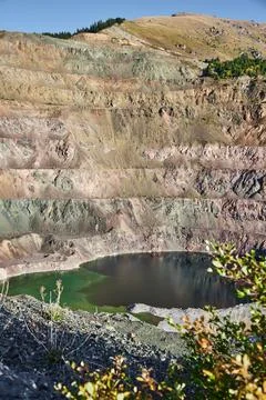 Old open mining pit with pond in mountain Stock Photos