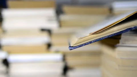 Old opened  book in focus on column of books Stock Footage 102728455