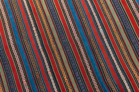 An old oriental carpet fabric with parallel colorful lines pattern, backgro.. Stock Photos