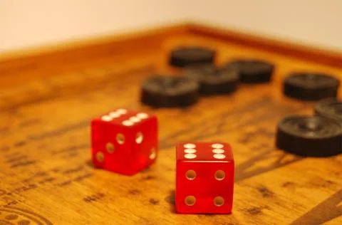 The old oriental game - backgammon, two red dice, black chips Stock Photos